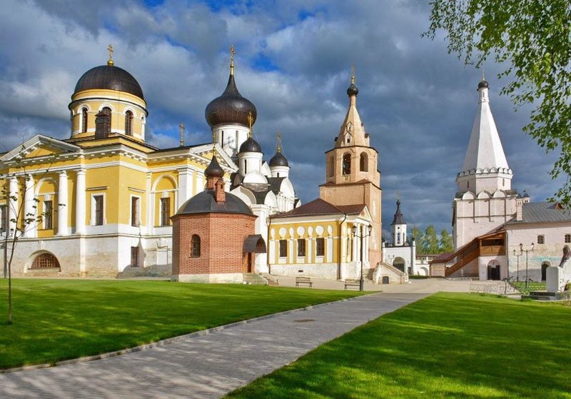 Двор Старицкого Успенского монастыря: храмы, колокольня и белая шатровая башня над зелёными газонами