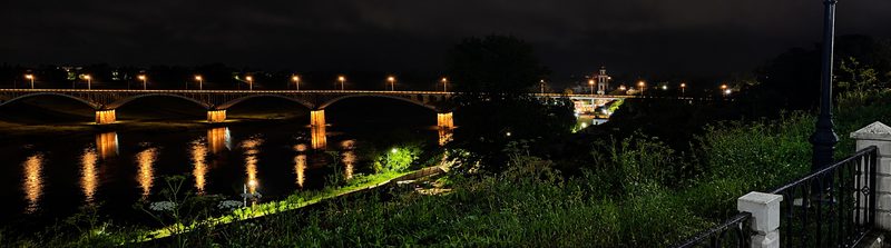 Ночной вид со смотровой площадки: освещённый мост через Волгу и его отражения в воде